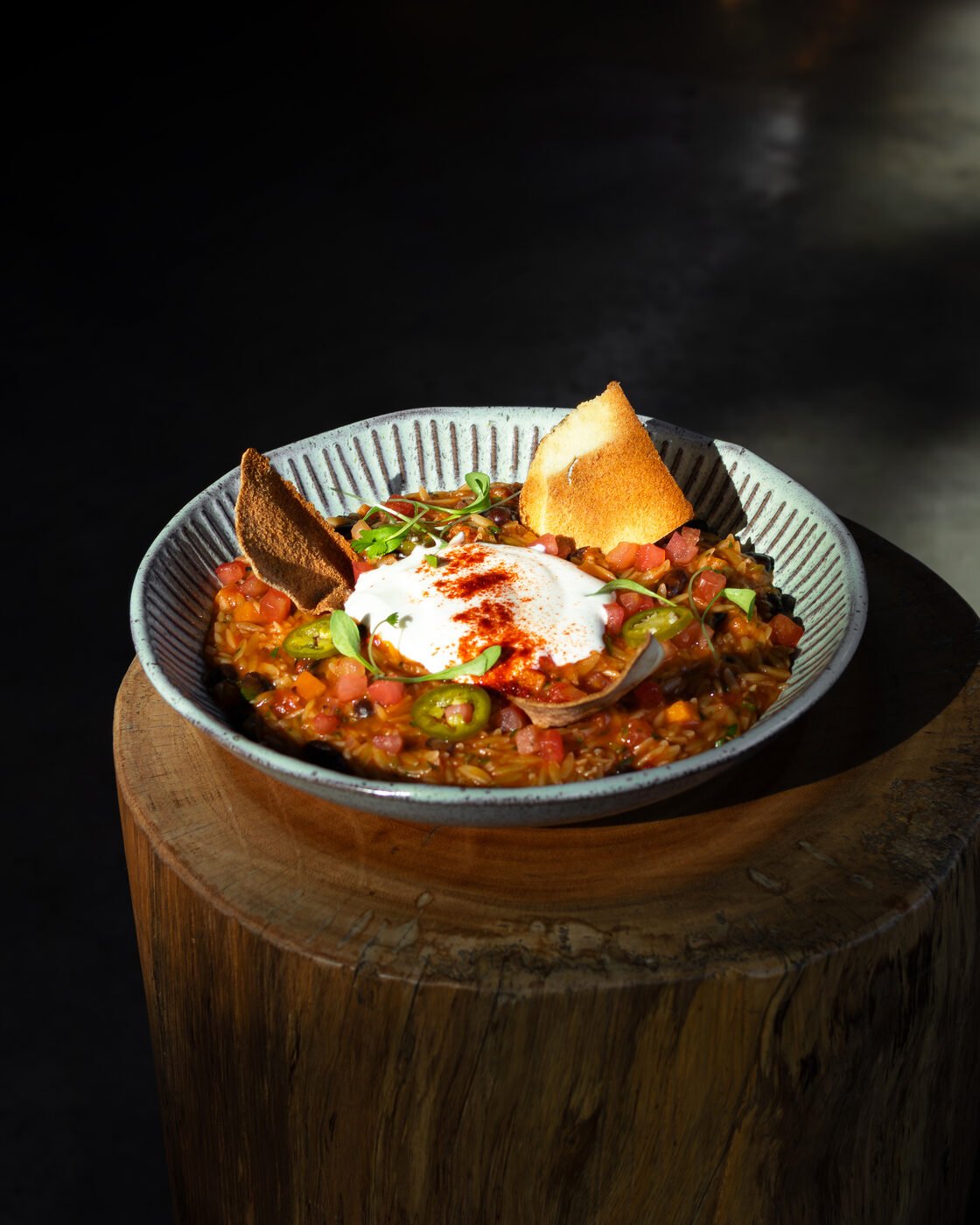 Chili de orzo com creme azedo, jalapeño e tortilla